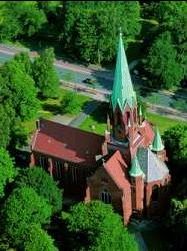 Luftbildaufnahme der Christus-und Garnisonkirche inmitten zahlreichen grünen Baumkronen.