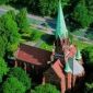 Luftbildaufnahme der Christus-und Garnisonkirche inmitten zahlreichen grünen Baumkronen.