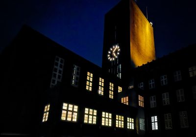 Aufnahme des Rathausturms bei Dunkelheit. Im Vordergrund die Lichter der Stadtkasse und des Ratssaals.