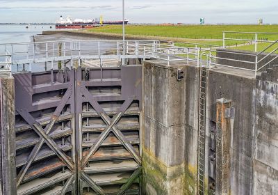 Blick in die Schleusenkammer der Seeschleuse. Hinter den verschlossenen Toren ist der Deich und das offene Meer bei Niedrigwasser zu sehen.